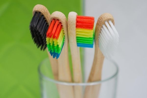 Colorful bamboo toothbrushes in glass cup