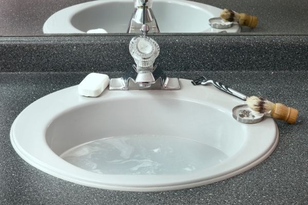 Bathroom sink with water and shaving kit