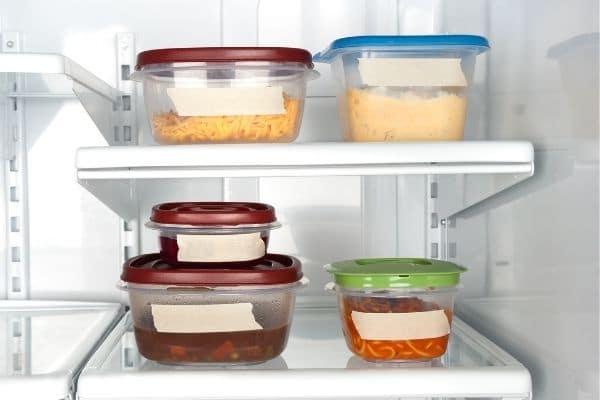 Leftover food in glass containers with labels in refrigerator