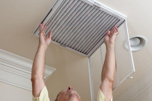 Man installing HVAC air filter improves indoor air quality
