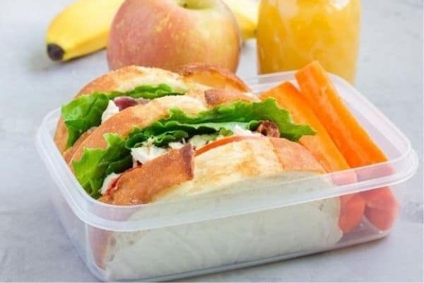 Packed lunch in container with fruit and juice